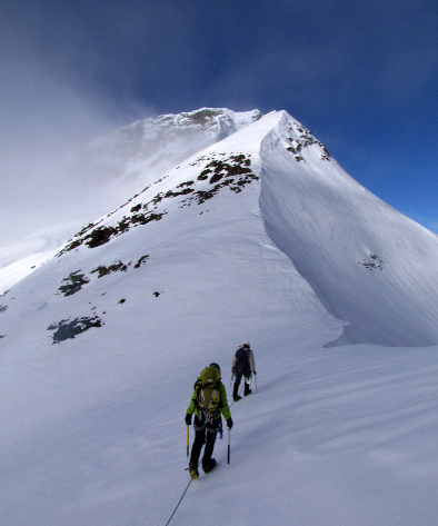 La passion et la partage de la montagne Hikers on the ridge of a snowy mounain with blue sky